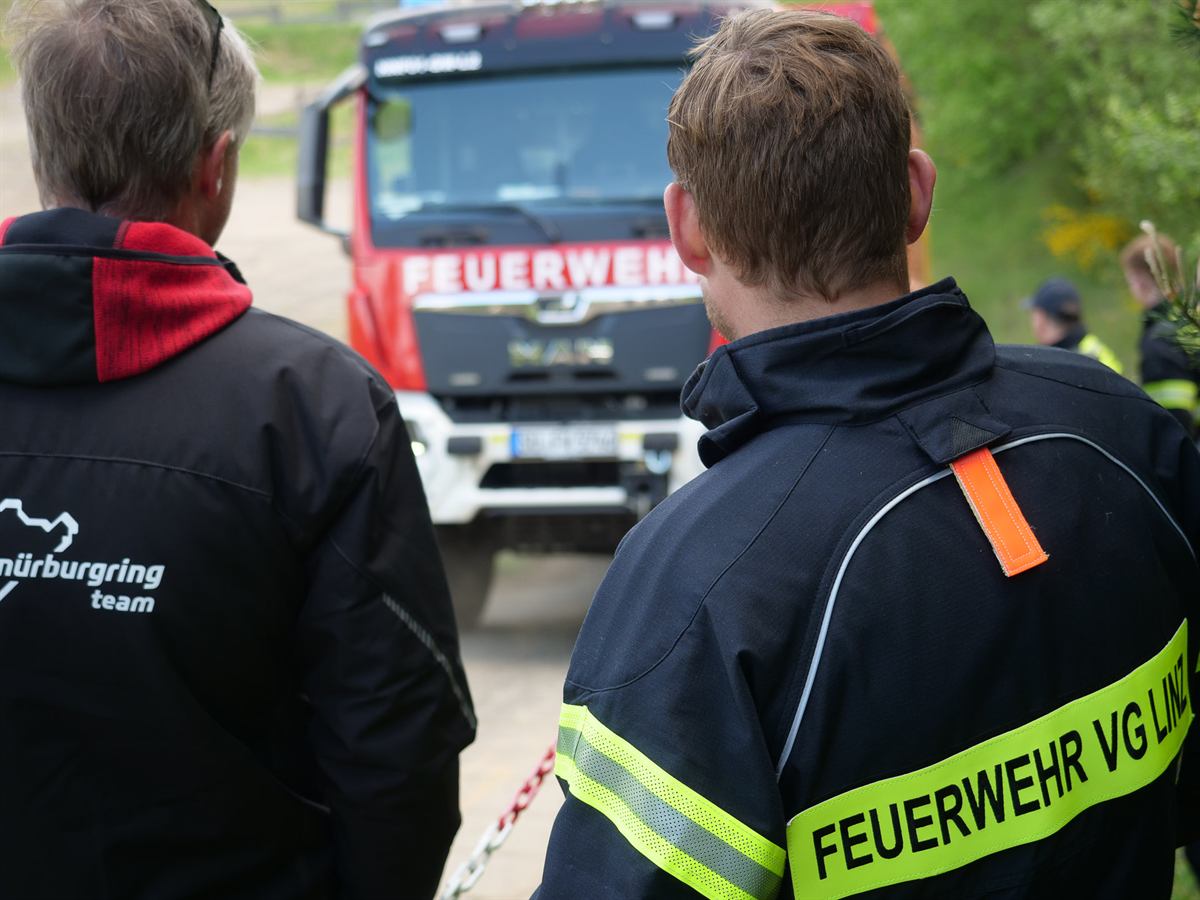 Teilnehmer beobachten ein Fahrzeug auf der Trainingsstrecke